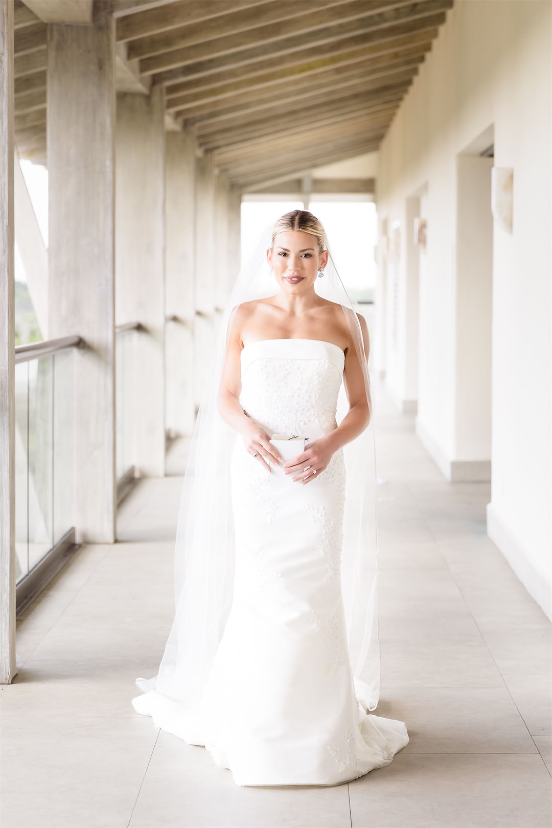 Bride standing in a hallway posing for Cancun wedding photographer.
